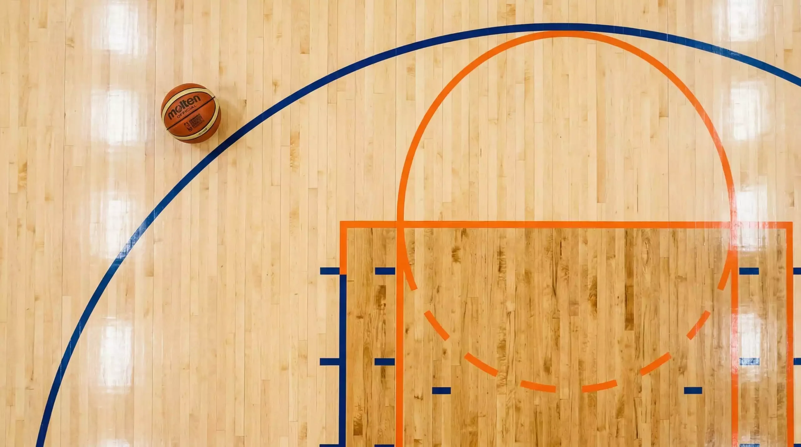 Cancha de baloncesto con líneas de tres puntos FIBA y NBA marcadas en colores distintos