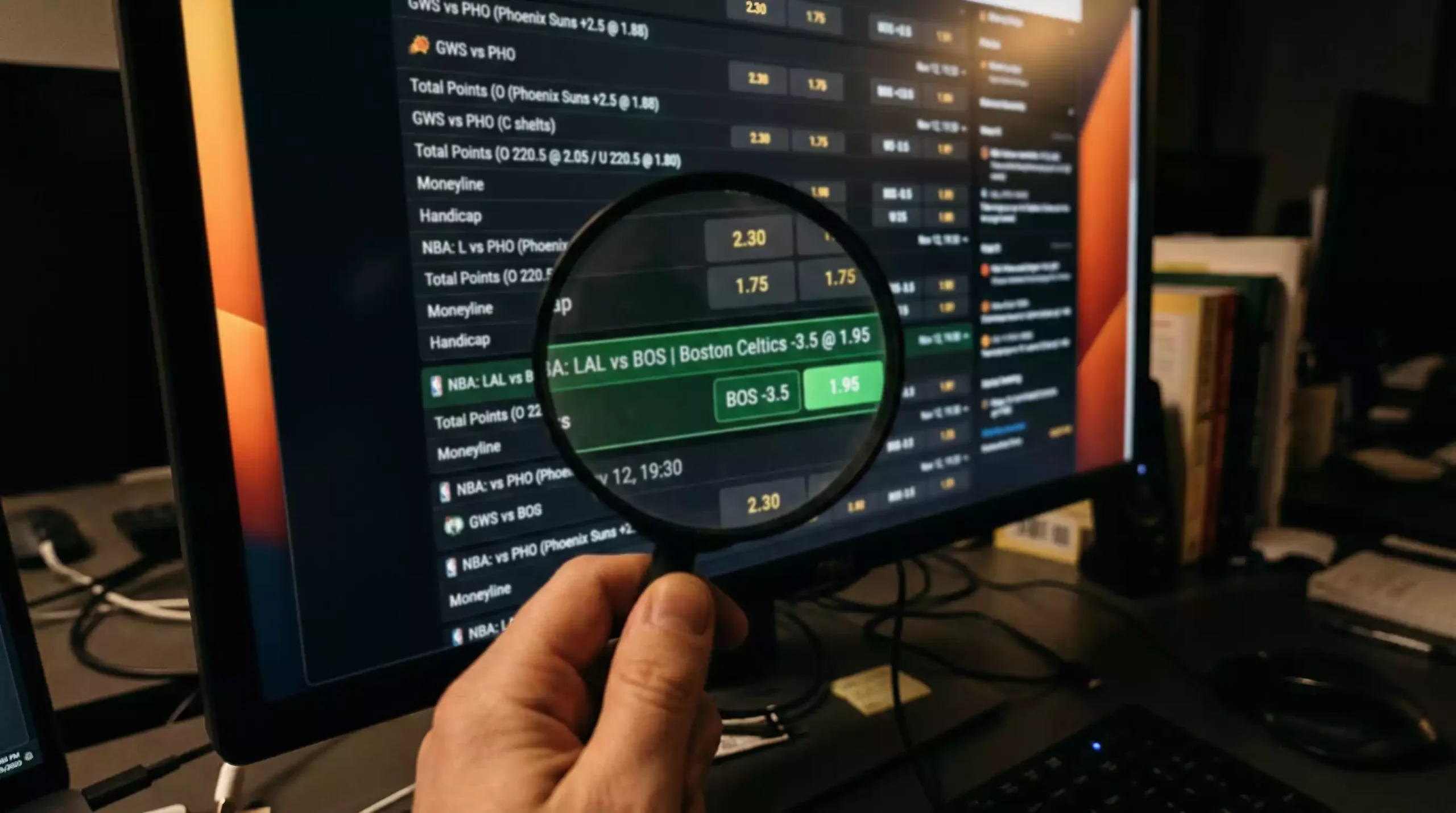 Lupa sobre una pantalla con cuotas de apuestas de baloncesto resaltando una cuota con valor